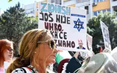 Une femme frappe sur une casserole à côté d'une pancarte disant « Le sionisme n'est pas encore mort, et nous ne savons pas quand il le sera », lors d'un rassemblement pro-palestinien et anti-Israël à Podgorica, au Monténégro, le 14 septembre 2025. (Photo de SAVO PRELEVIC / AFP)