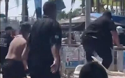Des agents de sécurité sautant par-dessus une clôture au milieu d'une bagarre au parc aquatique Yamit 2000, à Holon, le 15 août 2026. (Crédit : Capture d'écran partagée par Daniel Amram sur X)