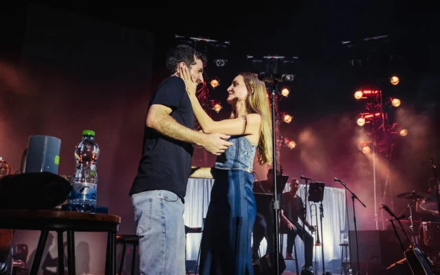 L'ancien otage Sagui Dekel-Chen et son épouse, Avital Dekel-Chen, interprétant les chansons qu'il a composées pendant sa captivité, sur la pelouse du kibboutz Nir Oz dans le cadre du Festival d'Israël, le 10 août 2026. (Crédit : Orit Pnini)