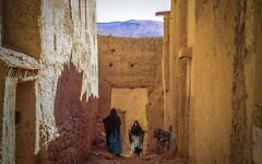 Des femmes discutent dans le quartier juif, ou « mellah », du village de Tagadirt, dans la région des oasis de Tata au Maroc, le 28 février 2023. (Crédit : Fadel Senna/AFP)
