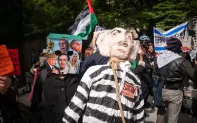 Un manifestant avec un sac sur la tête se trouve aux côtés d'une effigie du Premier ministre israélien, Benjamin Netanyahu, représente avec une corde autour du cou, à New York, le 24 septembre 2026. (Luke Tress/Times of Israel)