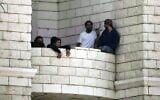 Des résidents d'implantation ayant attaqué un village palestinien sur le balcon d'un immeuble en construction, à Qusra, en Cisjordanie, le 29 août 2026. (Crédit : Majdi Mohammed/AP)
