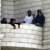 Des résidents d'implantation ayant attaqué un village palestinien sur le balcon d'un immeuble en construction, à Qusra, en Cisjordanie, le 29 août 2026. (Crédit : Majdi Mohammed/AP)