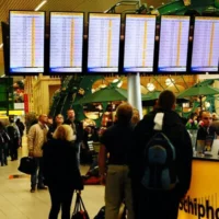 Illustration : Des passagers consultant les écrans affichant les vols retardés et annulés à l’aéroport international de Schiphol, près d’Amsterdam, après que de forts vents ont cloué au sol et dérouté des avions, le 4 novembre 2013. (Crédit : Tom Gandolfini/AFP)