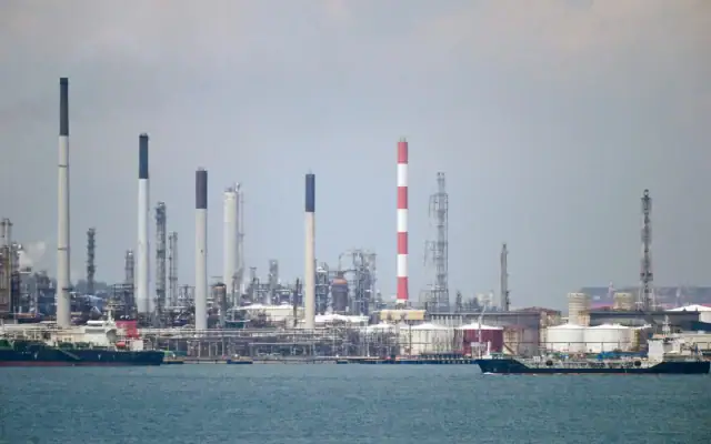 Illustration : Un pétrolier (à droite) passe devant des raffineries de pétrole sur l'île de Bukom, au large de Singapour, le 17 mars 2022. (Crédit : Roslan Rahman/AFP) Illustration : Un pétrolier (à droite) passe devant des raffineries de pétrole sur l'île de Bukom, au large de Singapour, le 17 mars 2022. (Crédit : Roslan Rahman/AFP)