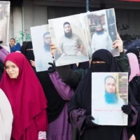 Des femmes brandissant des portraits d'islamistes détenus à la prison de Roumieh lors d'une manifestation réclamant leur libération, organisée à Tripoli, ville portuaire du nord du Liban, le 5 janvier 2025. (Crédit : Ibrahim Chalhoub/AFP)