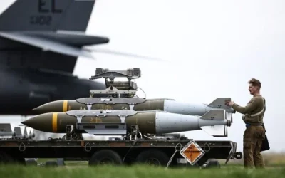 Du personnel au sol de l'armée de l'air américaine préparant des munitions d'attaque directe interarmées (JDAM) destinées à un bombardier B-1 Lancer sur le tarmac de la base RAF Fairford, dans le sud-ouest de l'Angleterre, le 12 mars 2026. (Crédit : Henry Nicholls/AFP)