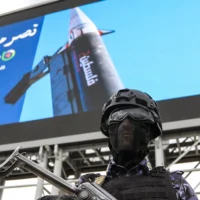 Un agent de sécurité monte la garde devant une immense image représentant un missile sur lequel est inscrit "Palestine", lors d'un rassemblement organisé par des partisans du groupe terroriste Houthi, soutenu par l'Iran, en solidarité avec l'Iran et le Liban dans le contexte de la guerre au Moyen-Orient, à Sanaa, la capitale, le 17 avril 2026. (Crédit: Mohammed HUWAIS/AFP)