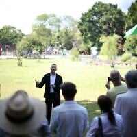 Le chef du Parti vert britannique, Zack Polanski, s'adresse à ses partisans, dont l'un brandit un drapeau palestinien, lors d'un rassemblement organisé dans le sud de Londres, le 24 juin 2026. (Crédit : Henry NICHOLLS/AFP)