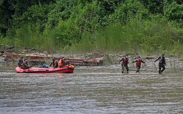 Des militaires népalais transportant les corps des victimes des inondations lors d'une opération de recherche le long de la rivière Narayani, à Bharatpur, dans le district de Chitwan au Népal, le 31 août 2026. (Crédit : Prakash Mathema/AFP)