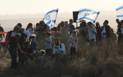 Des militants de droite participent à un rassemblement appelant au rétablissement des implantations juives dans la bande de Gaza, près de la frontière, dans le sud d'Israël, le 30 juillet 2025. (AP Photo/Ohad Zwigenberg)