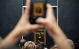 Une personne photographie le tableau de Léonard de Vinci, la Joconde, au musée du Louvre, le dimanche 31 août 2025, à Paris. (Crédit : Julia Demaree Nikhinson/AP)