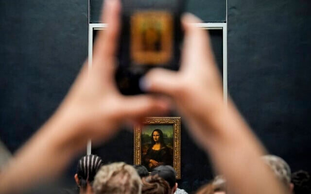 Une personne photographie le tableau de Léonard de Vinci, la Joconde, au musée du Louvre, le dimanche 31 août 2025, à Paris. (Crédit : Julia Demaree Nikhinson/AP)