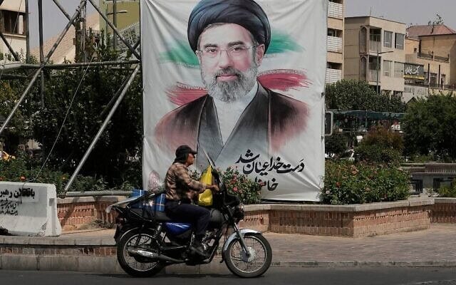 Un homme passant devant une banderole représentant le portrait du guide suprême iranien, l'ayatollah Mojtaba Khamenei, dans le centre-ville de Téhéran, en Iran, le 31 août 2026. (Crédit : Vahid Salemi/AP)