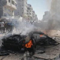 Des Palestiniens se rassemblent autour d'une voiture en train de brûler suite à une frappe de l'armée israélienne à Gaza City, le 31 août 2026. (AP Photo/Yousef Alzanoun)