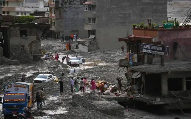 Des habitants récupèrent leurs effets personnels dans un bâtiment endommagé par une crue soudaine dans le district de Nuwakot, au Népal, le 1er septembre 2026. (Crédit: AP/Rajesh Kumar Singh)