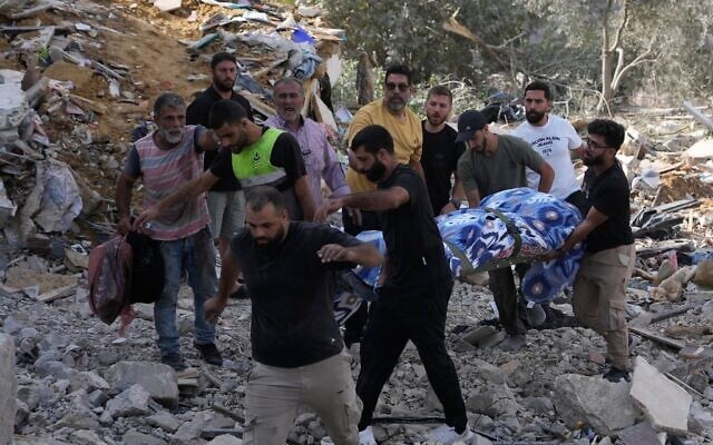 Des personnes transportant le corps d'une personne tuée dans une maison touchée par une frappe aérienne israélienne dans le village d'Arab Salim, au sud du Liban, le 6 septembre 2026. (Crédit : Mohammed Zaatari/AP)