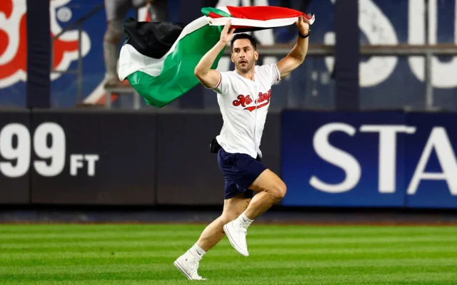 Un supporter brandissant un drapeau palestinien s'est précipité dans le champ extérieur lors de la septième manche d'un match de baseball opposant les Yankees de New York aux Mets de New York, le 11 septembre 2026, à New York. (Crédit: AP/Noah K. Murray) Un supporter brandissant un drapeau palestinien s'est précipité dans le champ extérieur lors de la septième manche d'un match de baseball opposant les Yankees de New York aux Mets de New York, le 11 septembre 2026, à New York. (Crédit: AP/Noah K. Murray)