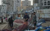 Des pêcheurs palestiniens travaillent sur leurs filets de pêche, le matin, dans le port endommagé de Gaza-City, le 13 septembre 2026. (Photo AP/Jehad Alshrafi)