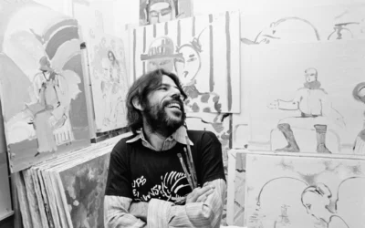 Peter Max, l'artiste américain qui avait donné une impulsion aux formes d'art cosmique dans les années 1960, assis au milieu de certaines de ses créations réalisées minute par minute dans son atelier new-yorkais, le 11 novembre 1973. (Crédit: AP/Dave Pickoff)