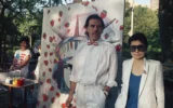 L'artiste Peter Max, à gauche, et Yoko Ono posent devant une fresque représentant la Statue de la Liberté et Strawberry Fields à Central Park, à New York, le 4 juillet 1986. (Crédit: AP/David Bookstaver)