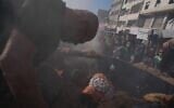 Des membres de la défense civile administrée par le Hamas s'affairent près d'un véhicule détruit suite à une frappe aérienne israélienne à Gaza-City, le 19 septembre 2026. (Crédit : AP Photo/Jehad Alshrafi)