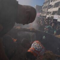 Des membres de la défense civile administrée par le Hamas s'affairent près d'un véhicule détruit suite à une frappe aérienne israélienne à Gaza-City, le 19 septembre 2026. (Crédit : AP Photo/Jehad Alshrafi)