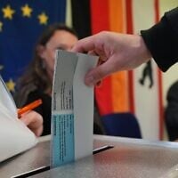 Un homme dépose son bulletin dans l'urne dans un bureau de vote lors des élections régionales de Berlin, à Berlin, en Allemagne, le 20 septembre 2026. (Crédit : AP Photo/Markus Schreiber)