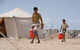 Des Yéménites déplacés transportant de l'eau dans le camp d'Al-Firdaws, à Ras Imran, dans la banlieue ouest d'Aden, au Yémen, le 21 septembre 2026. (Crédit : Abdulnasser Alseddik/AP Photo)
