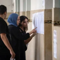 Des électeurs vérifiant leur nom sur les listes électorales à l'intérieur d'un bureau de vote lors des élections législatives à Rabat, au Maroc, le 23 septembre 2026. (Crédit : Mosa’ab Elshamy/AP)