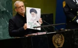 Le président iranien Masoud Pezeshkian tient une photo du défunt guide suprême iranien, l’ayatollah Ali Khamenei, lors de la 81ᵉ session de l’Assemblée générale des Nations unies, au siège de l’ONU, le 23 septembre 2026. (Crédit : Stefan Jeremiah/AP)