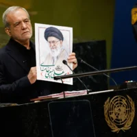 Le président iranien Massoud Pezeshkian tenant une photo du défunt guide suprême iranien, l’ayatollah Ali Khamenei, lors de la 81ᵉ session de l’Assemblée générale des Nations unies, au siège de l’ONU, le 23 septembre 2026. (Crédit : Stefan Jeremiah/AP)