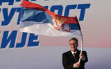 Le président serbe Aleksandar Vučić agitant un drapeau serbe lors d'un rassemblement du Parti progressiste serbe (SNS), au pouvoir, à Belgrade, en Serbie, le 27 juin 2026. (Crédit : Darko Vojinovic/AP)