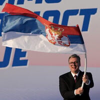 Le président serbe Aleksandar Vučić agitant un drapeau serbe lors d'un rassemblement du Parti progressiste serbe (SNS), au pouvoir, à Belgrade, en Serbie, le 27 juin 2026. (Crédit : Darko Vojinovic/AP)
