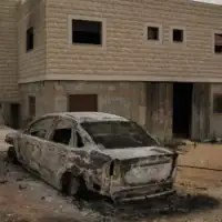 Une voiture incendiée devant l’une des deux maisons palestiniennes appartenant à la famille Tubasi, qui ont été incendiées par des extrémistes juifs, dans le village de Jalud en Cisjordanie, le 29 septembre 2026. (Crédit : Leo Correa/AP)
