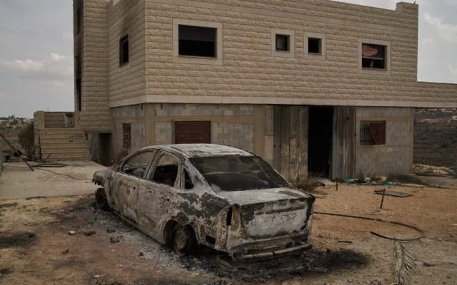 Une voiture incendiée  devant l’une des deux maisons palestiniennes appartenant à la famille Tubasi, qui ont été incendiées par des colons, dans le village de Jalud en Cisjordanie, le 29 septembre 2026. (Crédit: AP/Leo Correa)