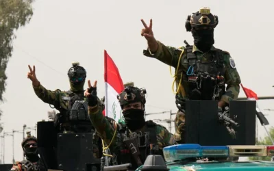 Des agents de sécurité irakiens faisant le signe de la victoire depuis des véhicules décorés de drapeaux nationaux, au sein d'un convoi célébrant le retrait total des troupes américaines d'Irak, à Bagdad, en Irak, le 30 septembre 2026. (Crédit : Hadi Mizban/AP)
