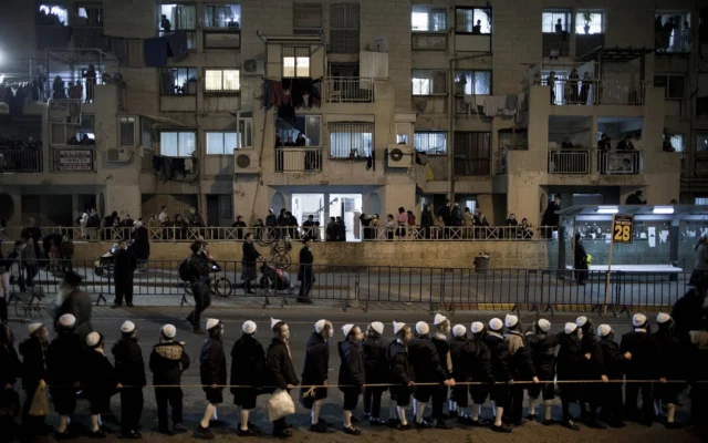 Illustration : Des Juifs ultra-orthodoxes appartenant au groupe hassidique Satmar, dirigé par l'Admor de Satmar de Williamsburg, le rabbin Zalman Leib Teitelbaum, attendant son arrivée dans le quartier juif ultra-orthodoxe de Mea Shearim, à Jérusalem, le 20 janvier 2013. (Crédit : Oded Balilty/AP)