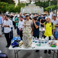 Des Israéliens priant dans un espace public lors d'une manifestation contre la décision de la municipalité de Tel Aviv d'interdire les prières avec séparation des sexes dans les espaces publics pendant Yom Kippour, sur la place Dizengoff, à Tel Aviv, le 8 août 2024. (Crédit : Avshalom Sassoni/Flash90)