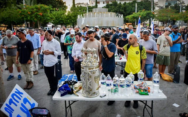 Des Israéliens priant dans un espace public lors d'une manifestation contre la décision de la municipalité de Tel Aviv d'interdire les prières avec séparation des sexes dans les espaces publics pendant Yom Kippour, sur la place Dizengoff, à Tel Aviv, le 8 août 2024. (Crédit : Avshalom Sassoni/Flash90)