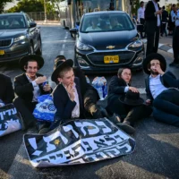 Des Juifs ultra-orthodoxes affrontant la police lors d’une manifestation contre la conscription des Juifs ultra-orthodoxes dans l’armée israélienne, sur la Route 4 près de Bnei Brak, le 8 août 2026. (Crédit: Avshalom Sassoni/Flash90)