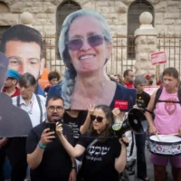 Des manifestants israéliens brandissant de grandes photos d'otages israéliens tués alors qu'ils étaient détenus par le Hamas, lors d'une manifestation réclamant la création d'une commission d'enquête nationale sur les défaillances liées au pogrom perpétré par le groupe terroriste palestinien le 7 octobre 2023, devant la résidence du Premier ministre, à Jérusalem, le 31 août 2026. (Crédit : Chaïm Goldberg/FLASH90)