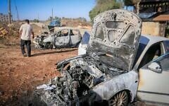 Des Palestiniens inspectant des voitures calcinées à la suite d'une attaque perpétrée par des résidents d'implantation, qui ont également tagué des graffitis en hébreu sur les murs d'une maison à Beita, au sud de Naplouse, en Cisjordanie, le 2 septembre 2026. (Crédit : Nasser Ishtayeh/Flash90)