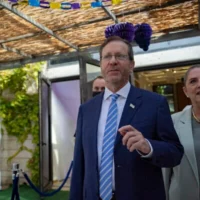 Le président Isaac Herzog et son épouse, Michal Herzog, accueillent des Israéliens dans la soukka de la Résidence présidentielle à Jérusalem au moment de la fête juive de Souccot, le 29 septembre 2026. (Yonatan Sindel/Flash90)
