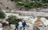Des Népalais se tenant au milieu des dégâts causés par les glissements de terrain et les inondations dans le village de montagne de Samagaun, où des dizaines de touristes israéliens se sont retrouvés piégés, le 27 septembre 2026. Crédit : Passportcard)