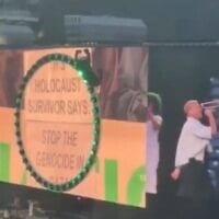 Macklemore se produisant au MetLife Stadium d'East Rutherford, dans le New Jersey, le 5 septembre 2026, tandis qu'un écran derrière lui affiche le message suivant : « Un survivant de la Shoah appelle à mettre fin au génocide à Gaza. » (Crédit : Capture d'écran/X)