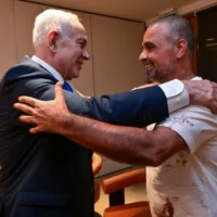 Le Premier ministre Benjamin Netanyahu rencontrant Yaniv, l'un des Israéliens qui ont aidé à maîtriser un copilote de Flydubai qui aurait tenté de détourner et de faire s'écraser un avion rempli d'Israéliens, lors du retour des passagers à l'aéroport Ben Gurion, le 30 septembre 2026. (Crédit : Kobi Gideon/GPO)