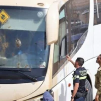 Des membres des forces de sécurité et des services d'urgence israéliens inspectent les lieux d'une attaque à la arme à feu sur un bus transportant des soldats dans la vallée du Jourdain, le 4 septembre 2022. (Ahmad Gharabli/AFP)