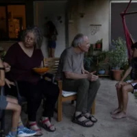 Aviva Siegel, 65 ans, et son mari Keith Siegel, 67 ans, tous deux anciens otages, discutant avec deux de leurs petits-enfants chez eux, au kibboutz Gazit, dans le nord d'Israël, le 6 août 2026. (Crédit : Shir Torem/Reuters)