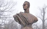 Une femme ajuste le ruban d’une couronne déposée au pied de la statue du nationaliste ukrainien Roman Shukhevych, dans la ville de Bilogorshcha, dans l’ouest de l’Ukraine, le 10 janvier 2010. Illustration (Crédit : Yuriy Dyachyshyn/AFP)